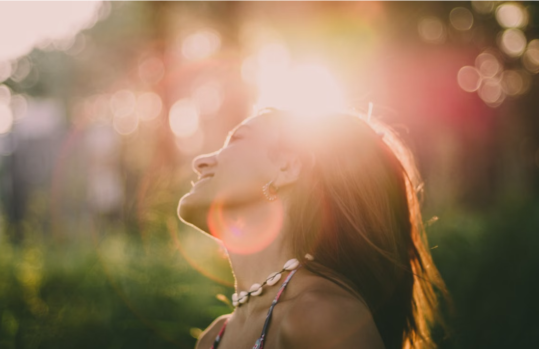 Mulher aproveitando a luz do sol ao ar livre